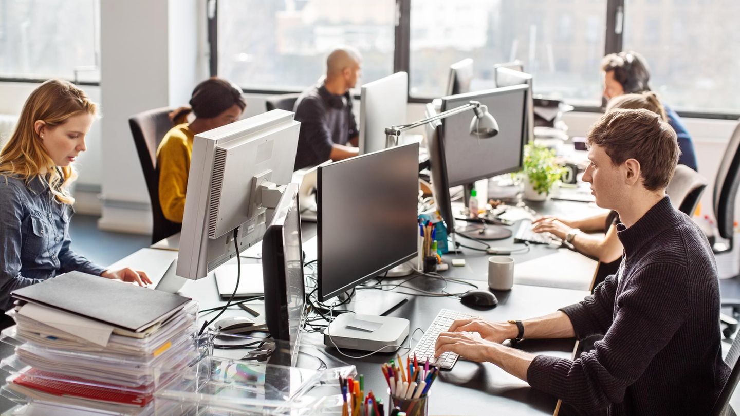 Junge Mitarbeiterinnen und Mitarbeiter arbeiten im Büro an ihren Computern