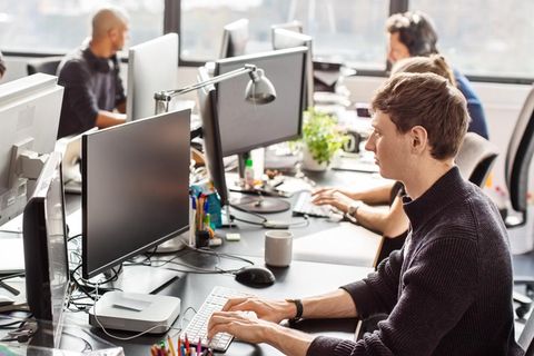 Gen-Z: Junge Mitarbeiterinnen und Mitarbeiter arbeiten im Büro an ihren Computern