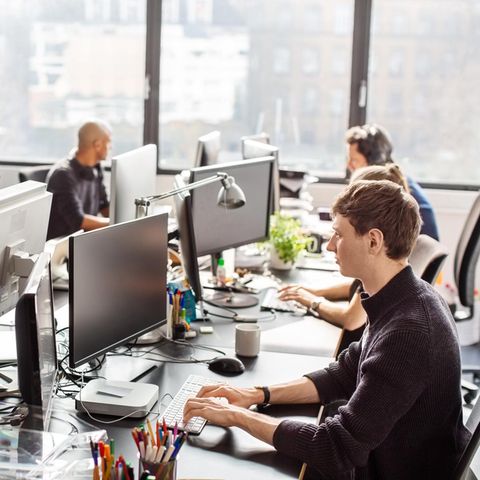 Gen-Z: Junge Mitarbeiterinnen und Mitarbeiter arbeiten im Büro an ihren Computern