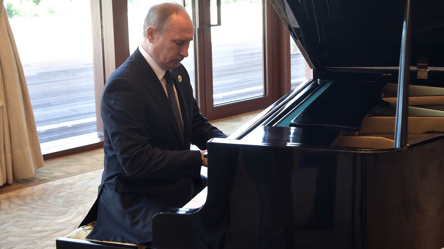 Der russische Präsident Wladimir Putin sitzt am Klavier