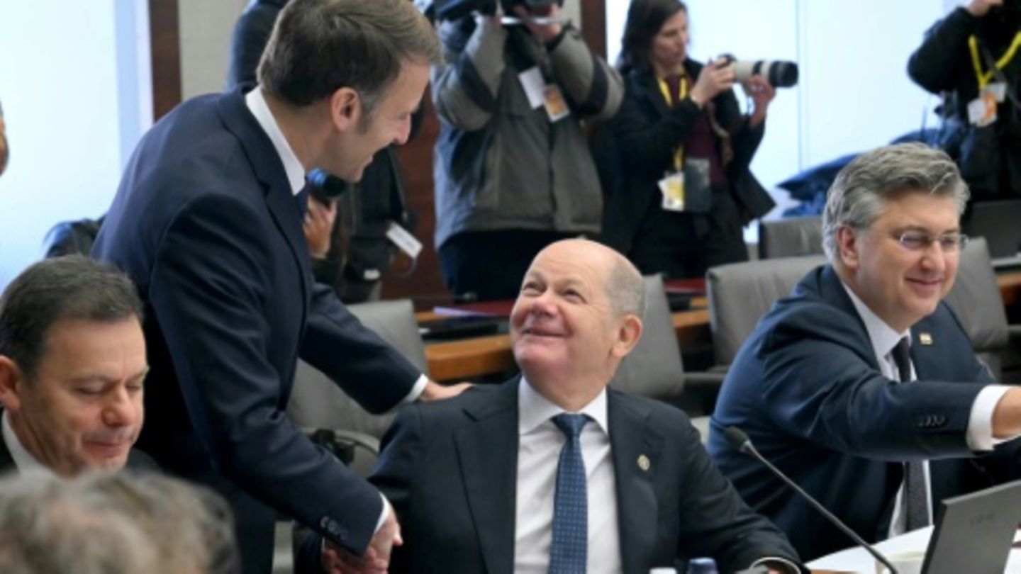 Frankreichs Präsident Macron (stehend) und Bundeskanzler Scholz