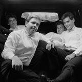 Eine Gruppe Männer in Anzügen auf der Rückbank