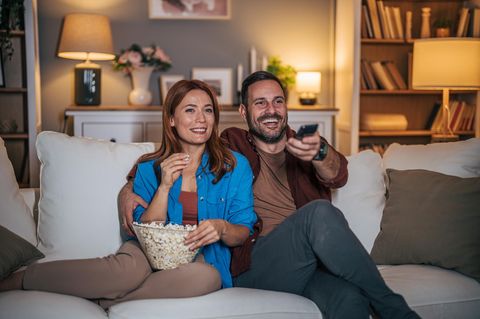 Ein Paar schaut auf dem Sofa Internet-Fernsehen.