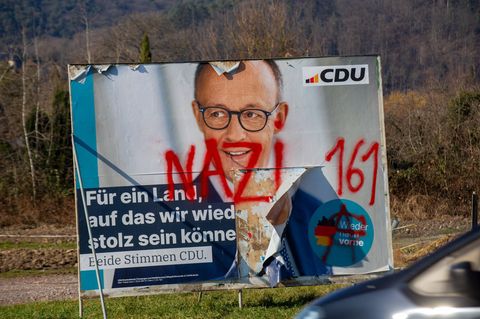 Auf ein Wahlplakat mit dem Gesicht von Friedrich Merz hat jemand das Wort Nazi geschmiert