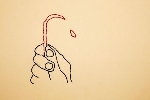 Eine gestickte Hand, die ein Messer hält