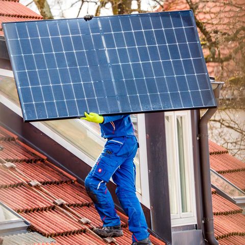 Ein Handwerker installiert eine Photovoltaik-Anlage (Teaserbild AfD-Wähler setzen auf Solar)
