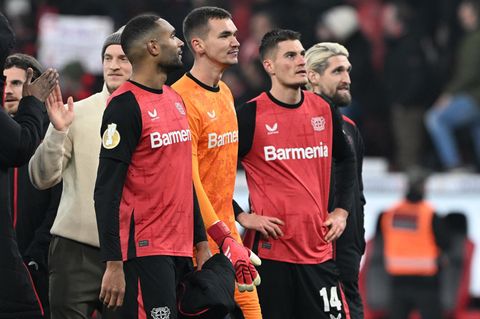 Vier Spieler von Bayer Leverkusen gehen in einer Reihe über den Platz