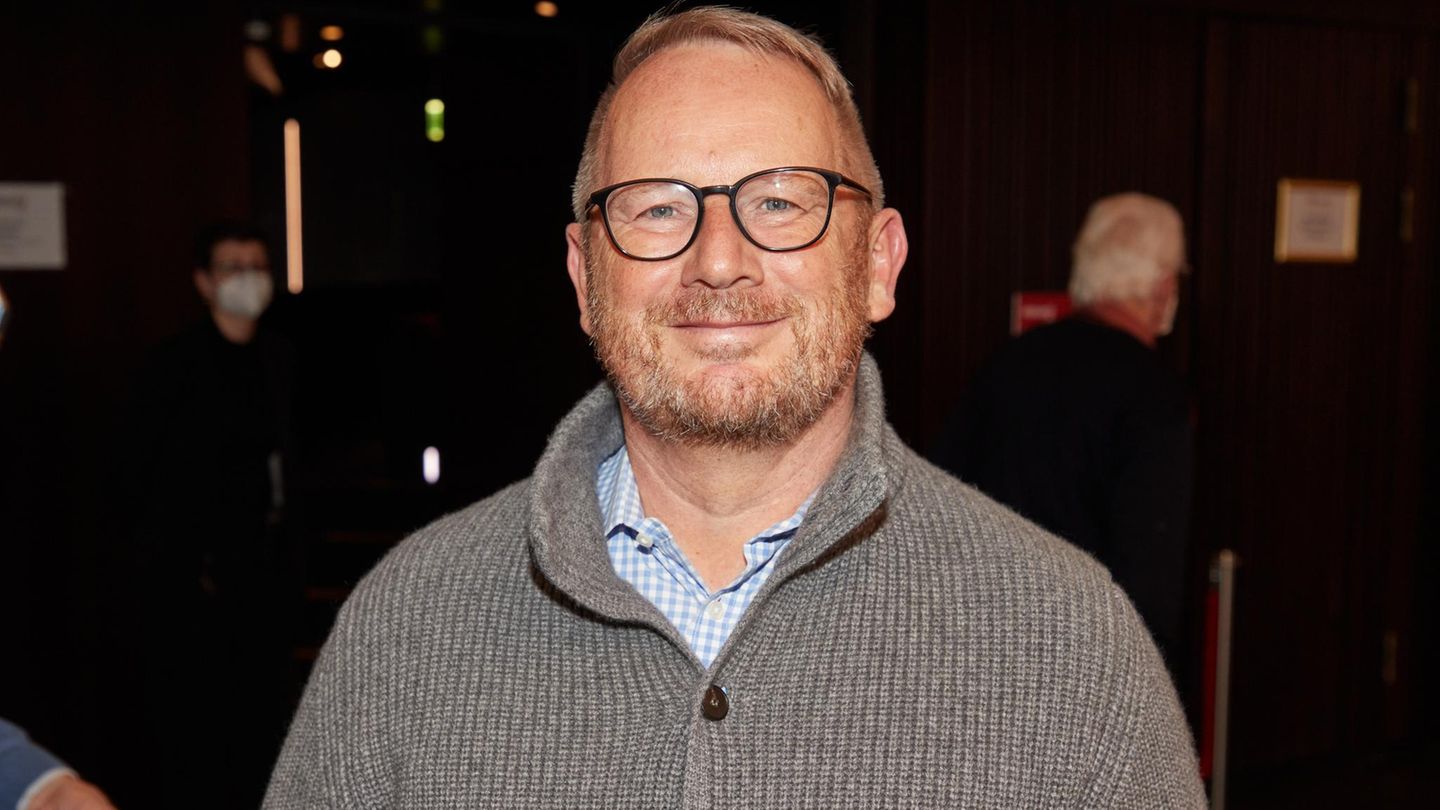 Johannes Kahrs in einer grauen Strickjacke lächelt in die Kamera