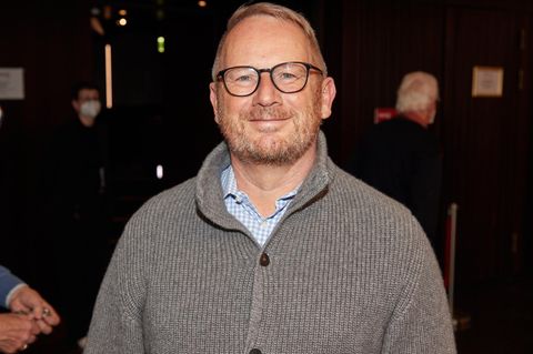 Johannes Kahrs in einer grauen Strickjacke lächelt in die Kamera