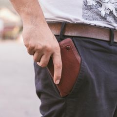 Rückansicht des Menschen halten Geldbörse in der Gesäßtasche seiner Hose chino