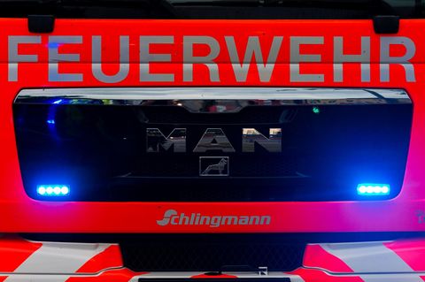 Der Kühlergrill eines Feuerwehr-Lkw mit eingeschaltetem Blaulicht