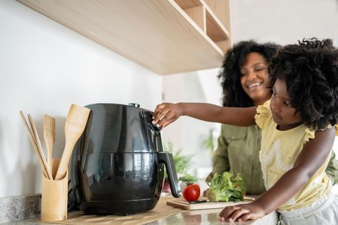 Airfryer im Angebot: Mutter und Kind an einer Heißluftfritteuse