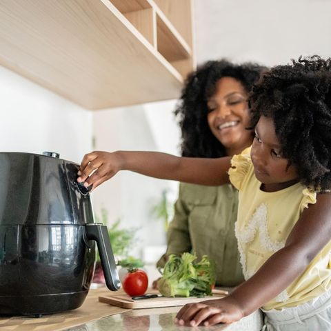 Airfryer im Angebot: Mutter und Kind an einer Heißluftfritteuse