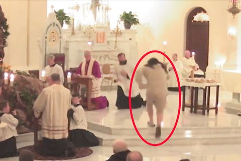 Ein Mann greift in einer Kirche einen der Priester an und reißt diesen zu Boden