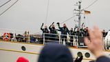Besatzungsmitglieder winken zum Abschied von Bord des Segelschulschiffs "Gorch Fock"