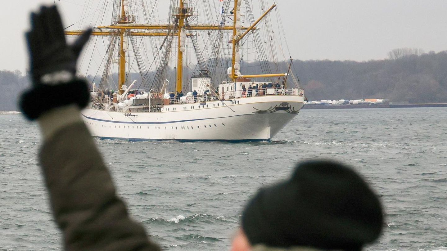 Eine Frau winkt beim Auslaufen der "Gorch Fock"