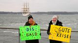 Die Hamburgerin Edeltraut Reim (r) und ihre Schwester Claudia Wagner stehen während des Auslaufens der "Gorch Fock" im Marinehafen mit Schildern, auf denen "Gute Reise" und "Bis bald" steht
