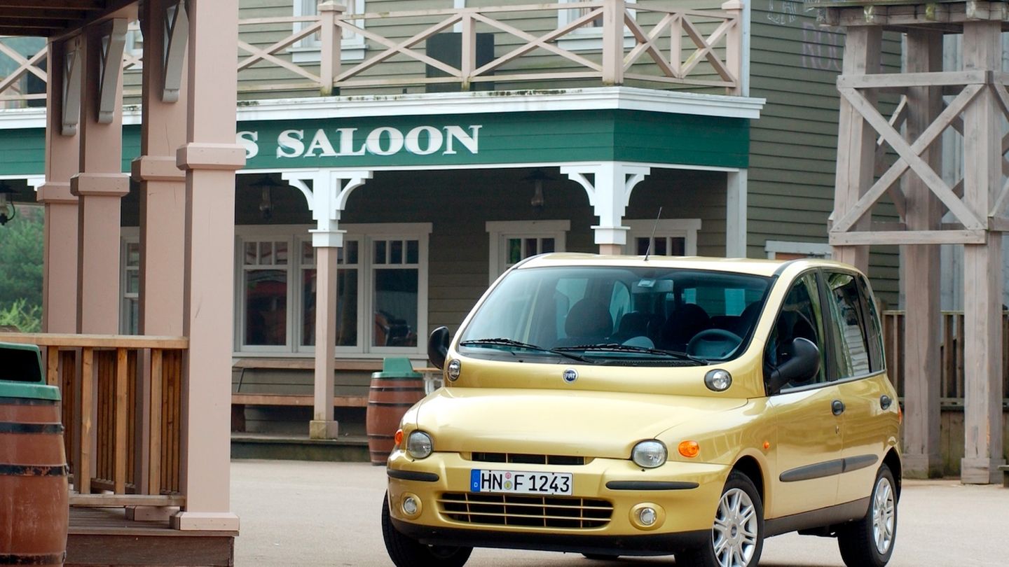 Ein gelber Fiat Multipla vor einem Saloon