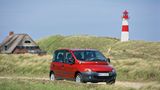 Ein roter Fiat Multipla fährt durch eine Hügellandschaft an der Nordsee