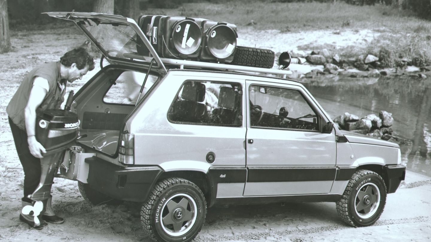Ein Mann hängt einen Bootsmotor an einen Panda 4×4 Anfibio