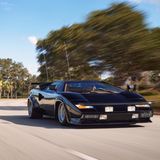 Ein schwarzer Lamborghini Countach rast über eine Straße