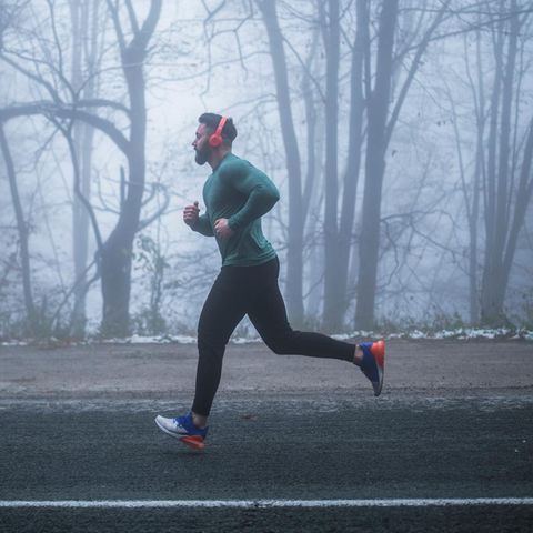 Joggen und Feinstaub: Junger Mann läuft durch den Nebel im Winter