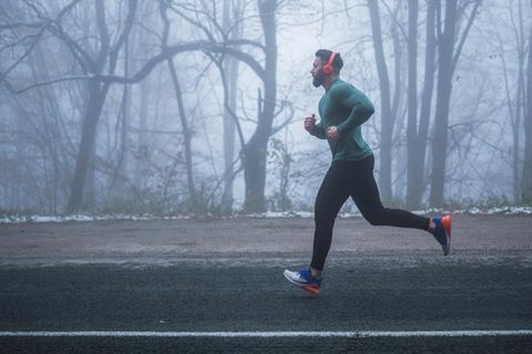 Joggen und Feinstaub: Junger Mann läuft durch den Nebel im Winter