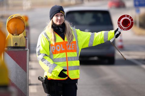Polizisten kontrollieren an einer mobilen Kontrollstelle kurz hinter der Grenze Fahrzeuge (Symbolfoto)
