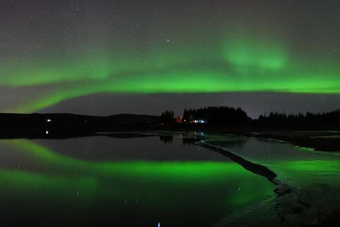 Polarlichter spiegeln sich im isländischen Fluss Ölfusá in der Nähe von Selfoss
