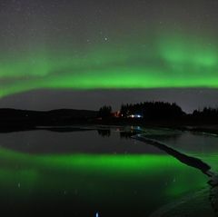 Polarlichter spiegeln sich im isländischen Fluss Ölfusá in der Nähe von Selfoss