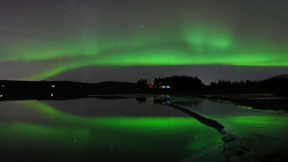 Warum die Chance Polarlichter zu sehen dieses Jahr besonders hoch ist Polarlichter spiegeln sich im isländischen Fluss Ölfusá in der Nähe von Selfoss