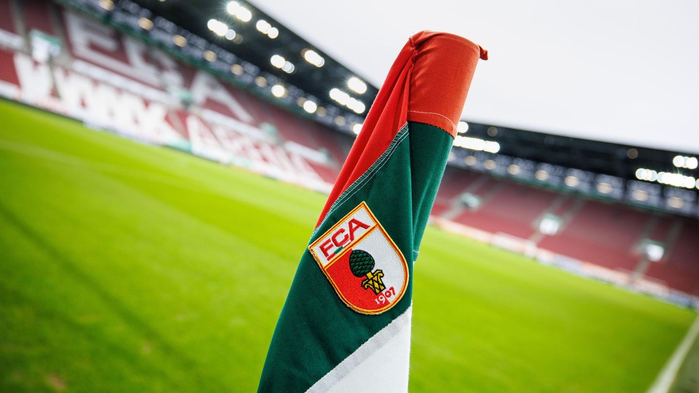 Das Logo vom FC Augsburg auf der Eckfahne vor dem leeren Stadion
