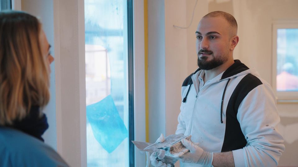 Der syrische Malermeister Ammar Bilal bei der Arbeit. Er wird von Jessy Wellmer interviewt