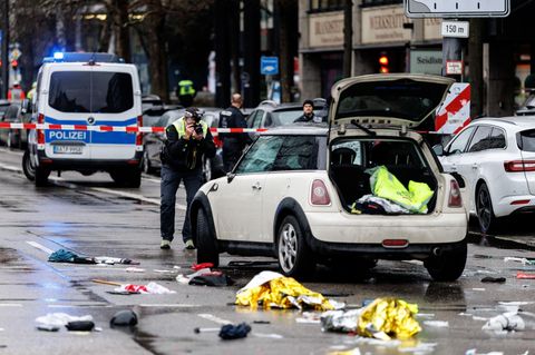 Ein Polizist fotografiert ein Auto am Einsatzort. In der Münchner Innenstadt ist ein Fahrzeug in eine Menschengruppe gefahren