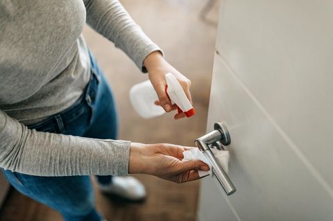 Eine Frau reinigt eine Türklinke
