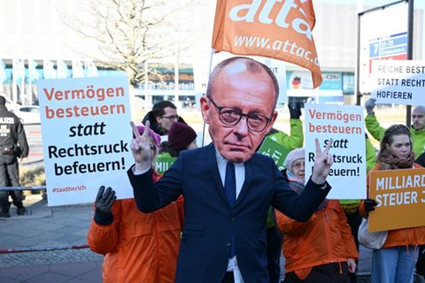 Demonstrant mit Merz-Maske bei Berliner Demo