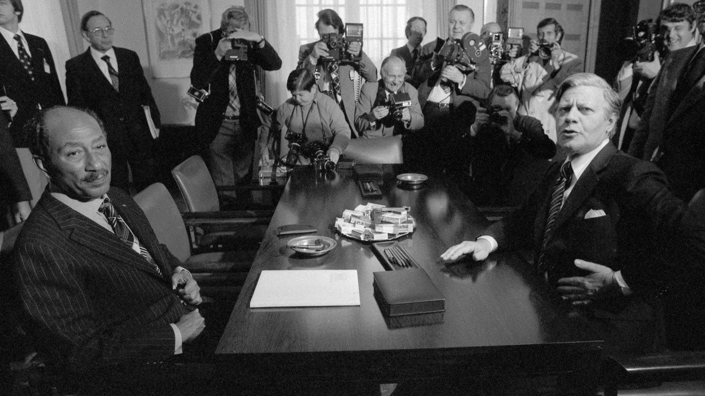 Ein Schwarz-weiß-Foto Helmut Schmidt an einem Tisch mit anderen Politikern