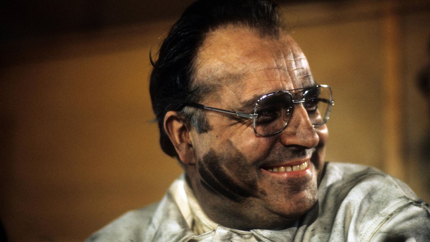 Helmut Kohl lächelt, er trägt eine Brille und sein Gesicht ist kohleverschmiert