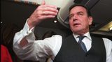 Gerhard Schröder gesitkuliert in einem Flugzeug