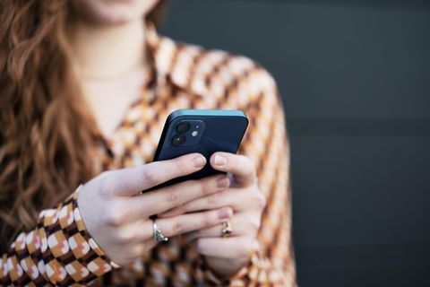 Eine Frau trippt auf einem Smartphone