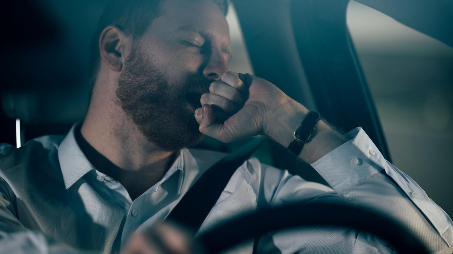 Mann schläft am Steuer seines Autos ein