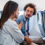 Mann mit Flugangst wird von Sitznachbarin beruhigt