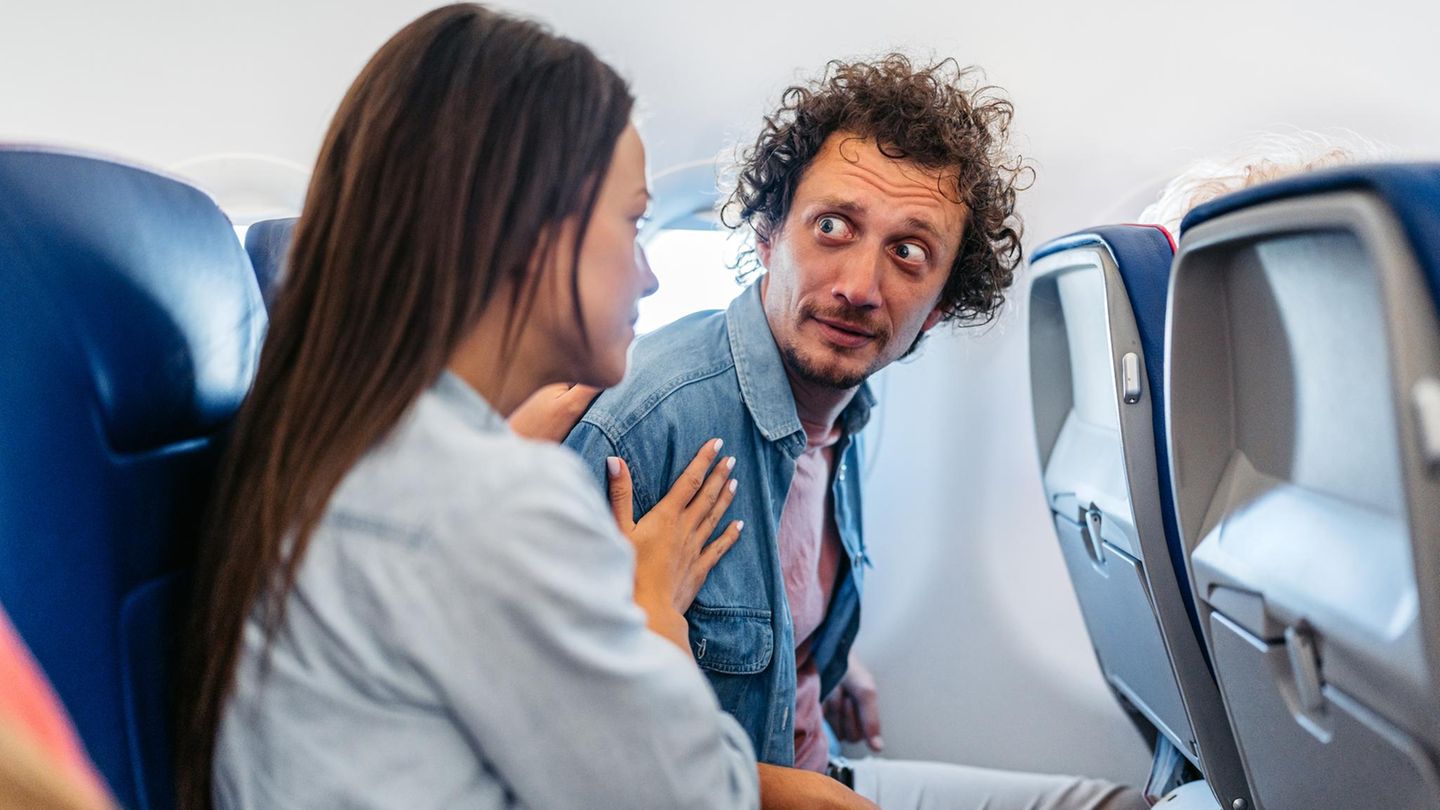 Mann mit Flugangst wird von Sitznachbarin beruhigt