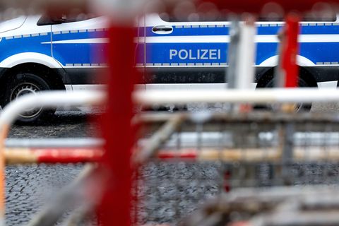 Absperrgitter und ein Polizeiauto stehen vor Beginn der Sicherheitskonferenz in der Nähe des Hotels Bayerischer Hof