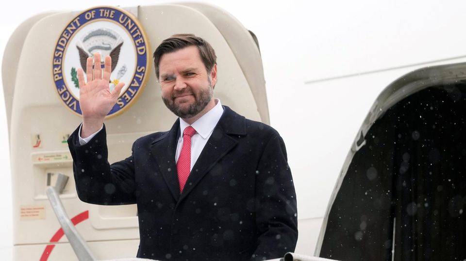 JD Vance winkt bei seiner Ankunft in München von der Flugzeugtreppe aus