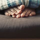 Körper-Fakten: Füße schauen aus der Bettdecke hervor