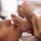 Körper-Fakten: Frau küsst Babyfüße