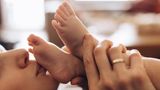 Körper-Fakten: Frau küsst Babyfüße