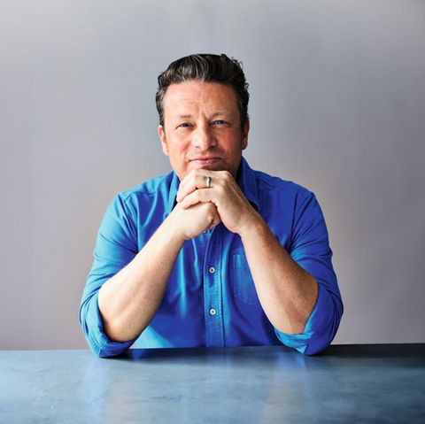 Jamie Oliver in einem blauen Hemd vor einer grauen Wand