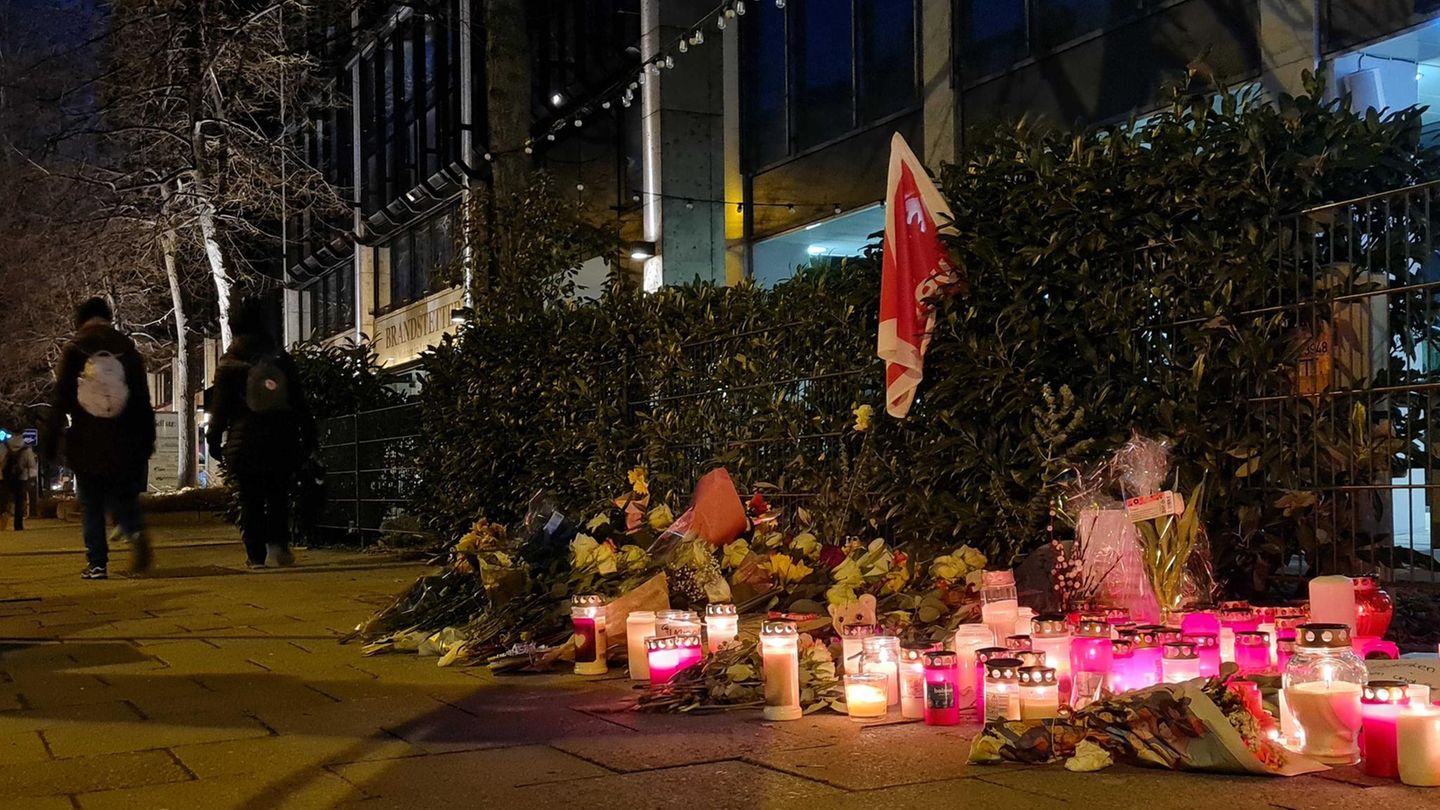 Blumen und Kerzen stehen auf einem Bürgersteig in München